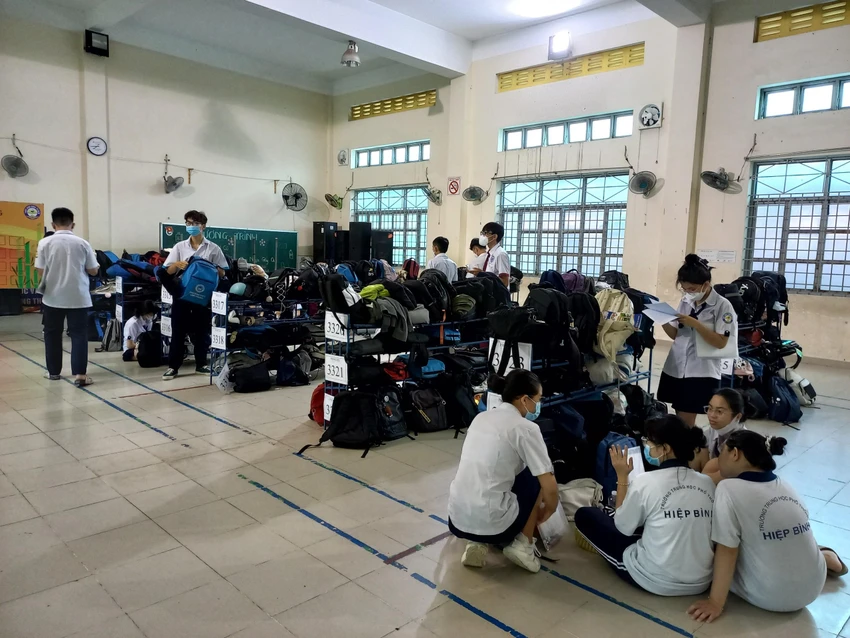 Một số em tranh thủ ôn bài tại phòng gửi đồ, một số chạy tới chạy lui cất hoặc lấy đồ dùng trước khi về phòng thi.