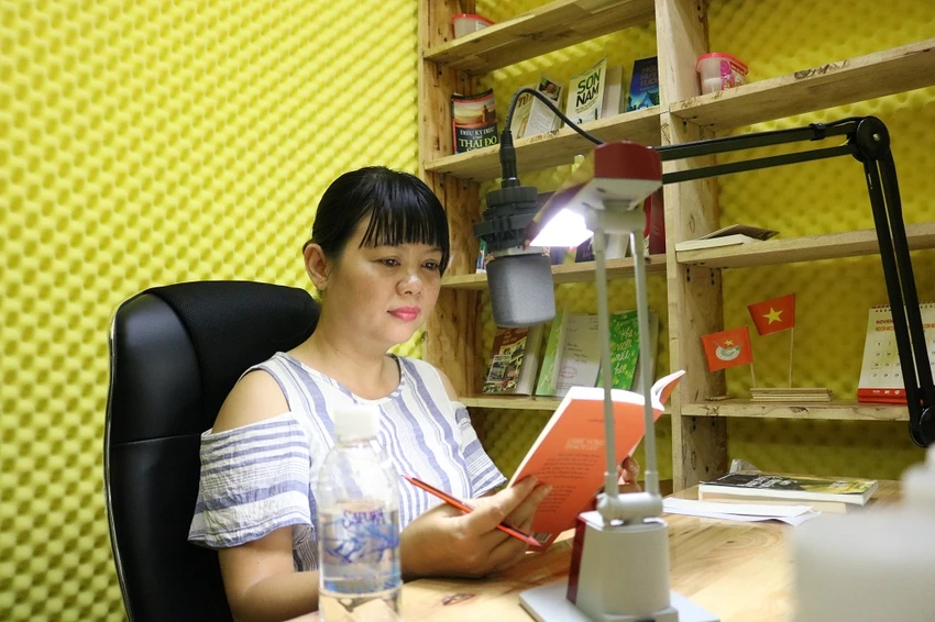 Một tình nguyện viên đang đọc sách tại phòng thu..