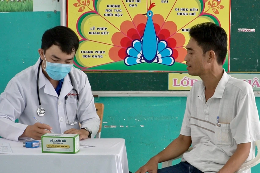 Ông Lê Ngọc Sơn được thăm khám và phát thuốc đau lưng miễn phí. Ảnh: NHẬT DIỄM