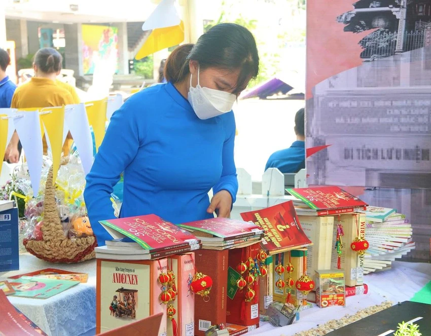 Chị Lê Nguyễn Thùy Linh miệt mài say sưa trưng bày những quyển sách. Ảnh: THẢO PHƯƠNG