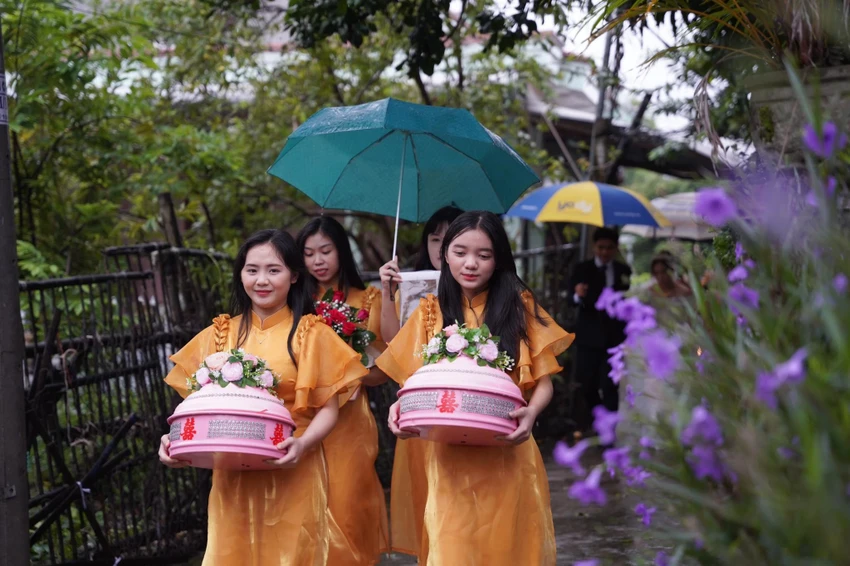 Nguyễn Ái Phi (bên trái) "đội mưa" bưng quả cho chị gái. Ảnh: NVCC