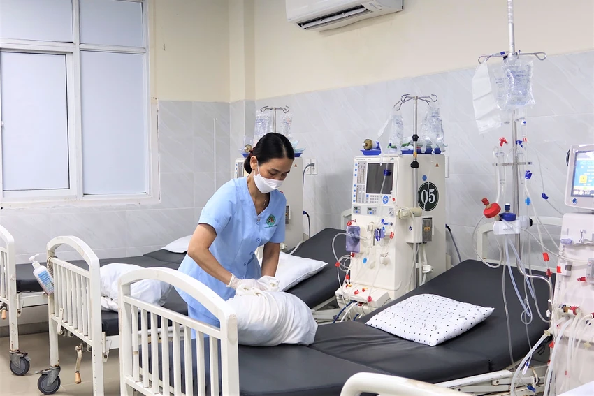 Đã 9 giờ đêm, hộ lý Đinh Thị Xuân còn ở lại bệnh viện để thu gom chăn ga, vỏ gối đi gửi giặt. Ảnh: THẢO PHƯƠNG
