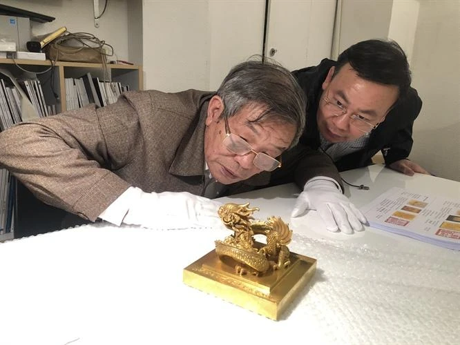 TS. Phạm Quốc Quân, TS. Nguyễn Văn Đoàn, Giám đốc Bảo tàng lịch sử quốc gia nghiên cứu, đánh giá hiện trạng và tính xác thực của ấn vàng “Hoàng đế chi bảo” lưu giữ tại Văn phòng Hãng đấu giá Millon. Ảnh: Cục Di sản văn hóa