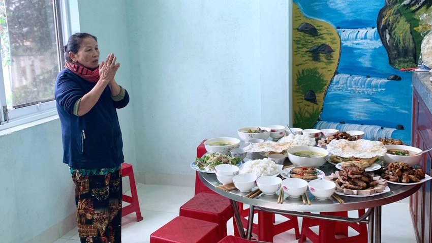 Má tôi đang đứng thành kính trước ông bà tổ tiên trong mâm cúng ngày tết Má tôi đang đứng thành kính trước ông bà tổ tiên trong mâm cúng ngày tết