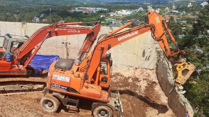 Nhiều xe máy múc đang phá dỡ taluy trái phép. Ảnh: VÕ TÙNG