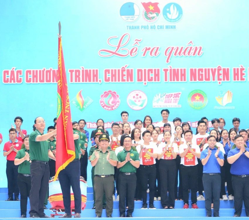 Phó Bí thư Thành ủy TP.HCM Nguyễn Hồ Hải trao cờ cho Chỉ huy trưởng chiến dịch tình nguyện hè. ẢNH: THIỆN HỢP