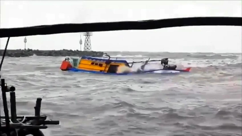 Một tàu cá đi từ ngoài biển vào bờ để tránh mưa bão, tuy nhiên, khi đến gần bờ thì bị sóng đánh chìm làm hai cha con mất tích và đã tìm thấy thi thể người con. Ảnh: TUẤN HOÀNG