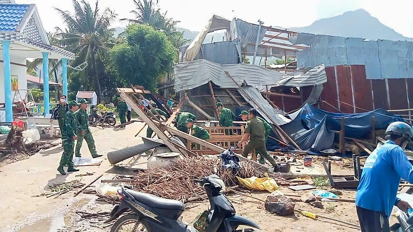 Lực lượng Công an, dân quân, Biên phòng... hỗ trợ người dân dọn dẹp hiện trường. Ảnh: PHÚ HỮU