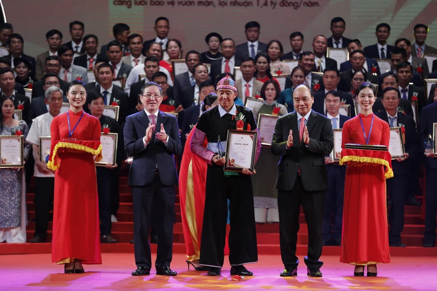 Chủ tịch nước Nguyễn Xuân Phúc và Chủ tịch Trung ương Hội Nông dân Việt Nam Lương Quốc Đoàn trao danh hiệu và kỉ niệm chương cho các nông dân Việt Nam xuất sắc. Ảnh: DV