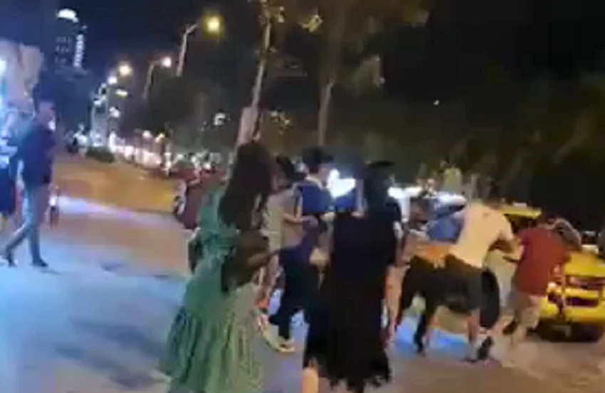 Hình ảnh hướng dẫn viên bị kẹp cổ lôi đi trước mặt khách. Ảnh cắt từ clip Hình ảnh hướng dẫn viên bị kẹp cổ lôi đi trước mặt khách. Ảnh cắt từ clip