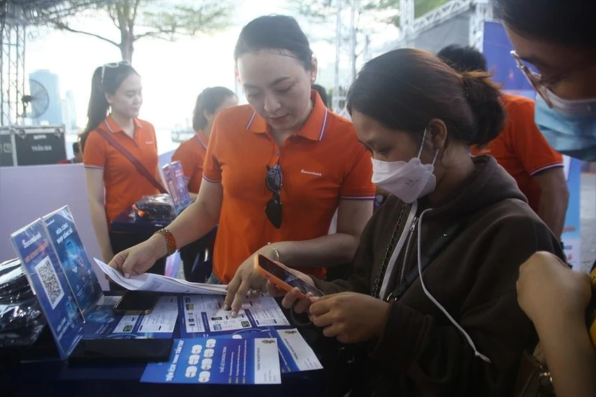 Người dân tìm hiểu "chuyến xe không tiền mặt". Ảnh: NGÔ QUANG Người dân tìm hiểu "chuyến xe không tiền mặt". Ảnh: NGÔ QUANG
