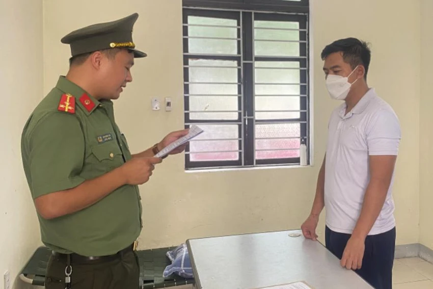Công an tống đạt quyết định khởi tố bị can đối với Nguyễn Quyết Chiến. Ảnh: CA