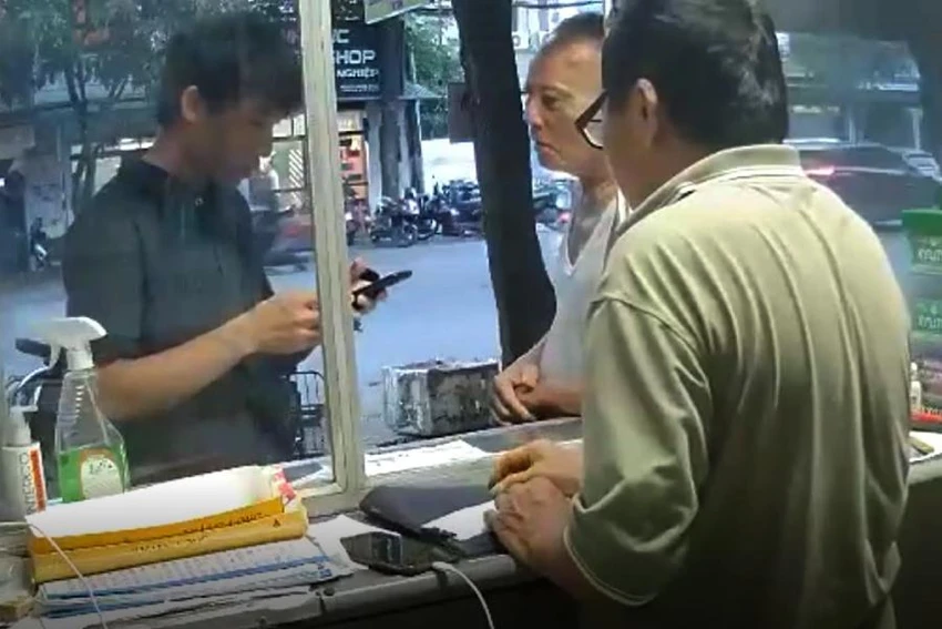 Hoàng (bìa trái) đến hỏi mua 4 thẻ cào điện thoại. Ảnh cắt từ video clip.