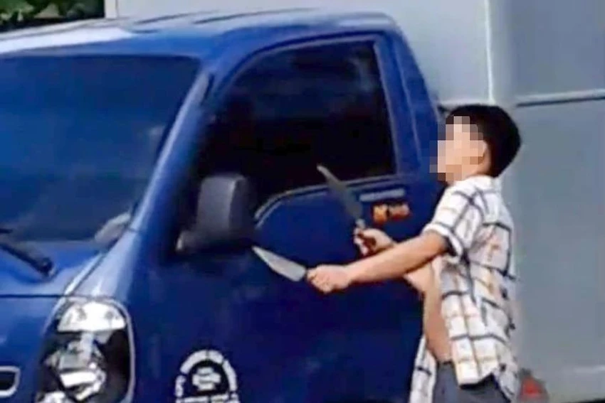 Thanh niên hai tay hai dao chém vỡ kính xe tải. Ảnh cắt từ video clip. Thanh niên hai tay hai dao chém vỡ kính xe tải. Ảnh cắt từ video clip.