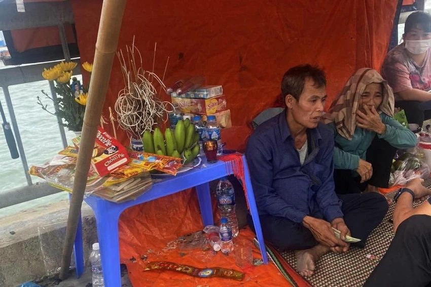 Bố, mẹ của anh Hoàng lập bàn thờ, ngồi chờ tìm kiếm con ở cầu Bãi Cháy. Ảnh: TT.