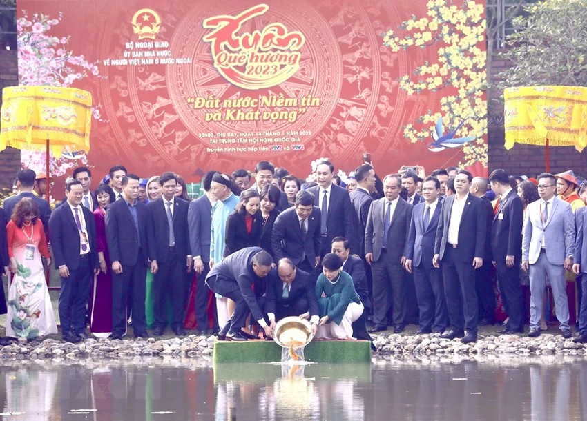Chủ tịch nước Nguyễn Xuân Phúc và Phu nhân cùng các đại biểu kiều bào thả cá chép tiễn ông Công, ông Táo theo phong tục truyền thống tại Hồ sen trong Khu di tích Hoàng Thành Thăng Long. Ảnh: TTXVN