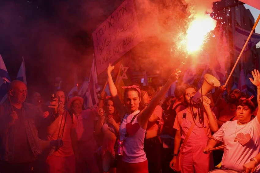 Người biểu tình Israel cầm loa và pháo sáng tại TP Tel Aviv. Ảnh: REUTERS Người biểu tình Israel cầm loa và pháo sáng tại TP Tel Aviv. Ảnh: REUTERS