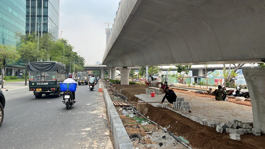 Các công nhân đang lát gạch, thảm nhựa. Ảnh: ĐT.