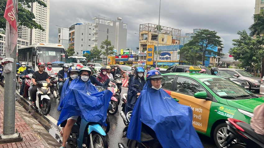Người dân chật vật di chuyển trong cơn mưa chiều ngày 27-9. Ảnh: ĐT.