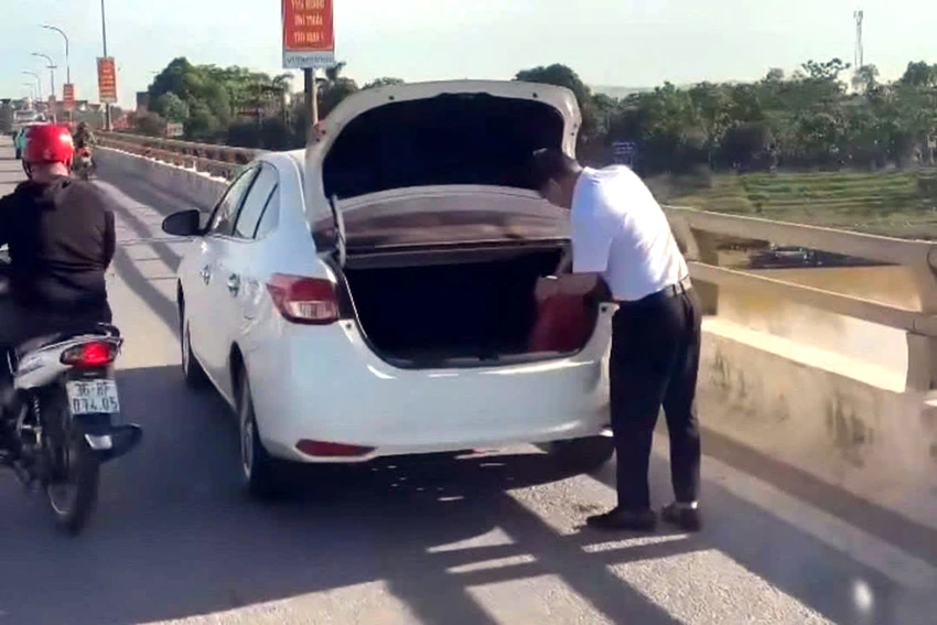 Cảnh sát xác minh vụ tài xế dừng xe trên cầu Vạn Hà thản nhiên vứt đồ xuống sông.jpg