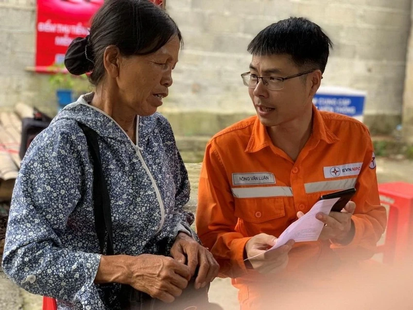 Nhân viên EVNPC hướng dẫn khách hàng thanh toán tiền điện qua ứng dụng ngân hàng.