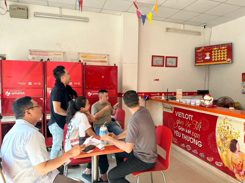 Bên trong một điểm bán vé số Vietlott có đông đảo người chơi theo dõi kết quả mở thưởng Keno trực tiếp trên màn hình.
