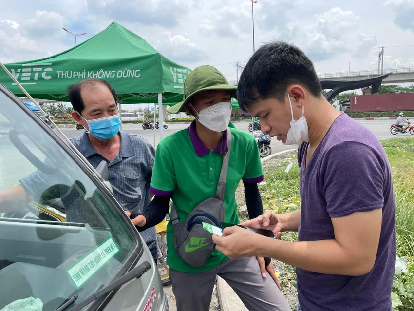 Nhân viên của các đơn vị thu phí đang hướng dẫn người dân kích hoạt tài khoản thu phí không dừng tại trạm thu phí xa lộ Hà Nội.