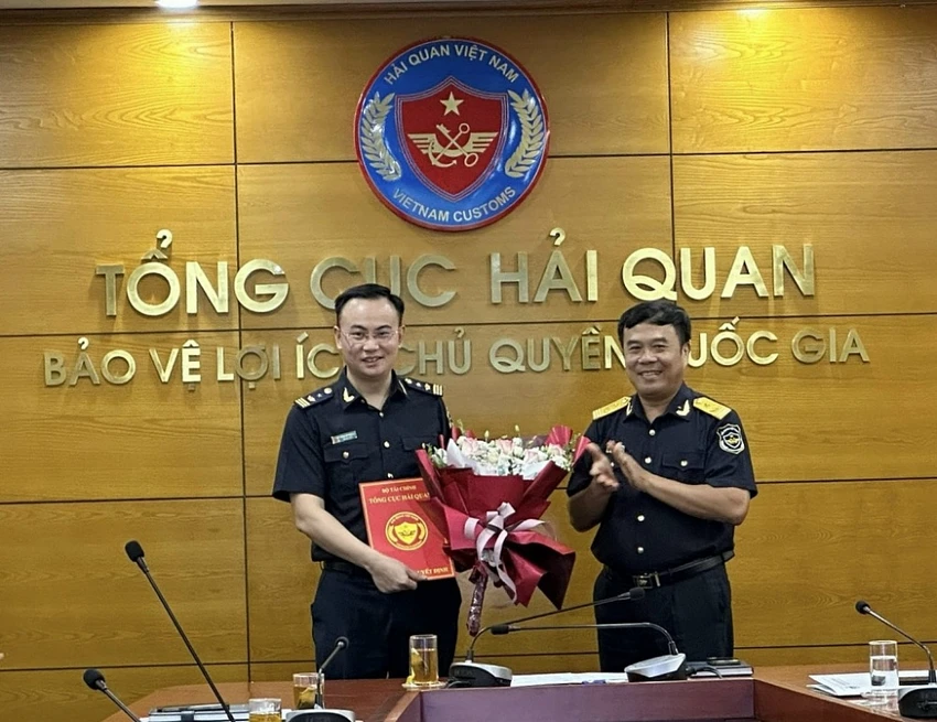 Phó Tổng cục trưởng Tổng cục Hải quan Nguyễn Văn Thọ (bên phải) trao quyết định và tặng hoa chúc mừng ông Trần Lê Thăng..jpeg