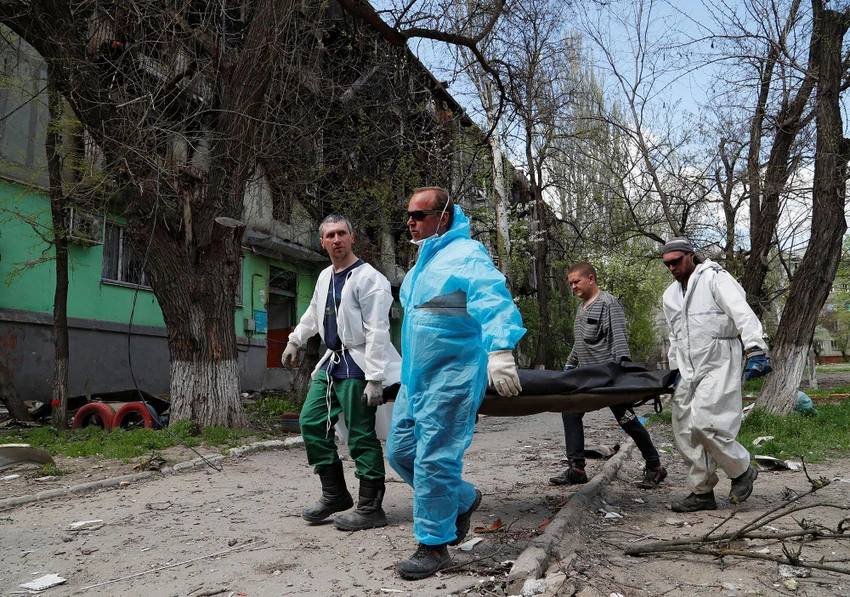 Những người ở Ukraine đang khiêng một người chết do pháo kích ở TP Mariupol hôm 28-4. Ảnh: REUTERS Những người ở Ukraine đang khiêng một người chết do pháo kích ở TP Mariupol hôm 28-4. Ảnh: REUTERS