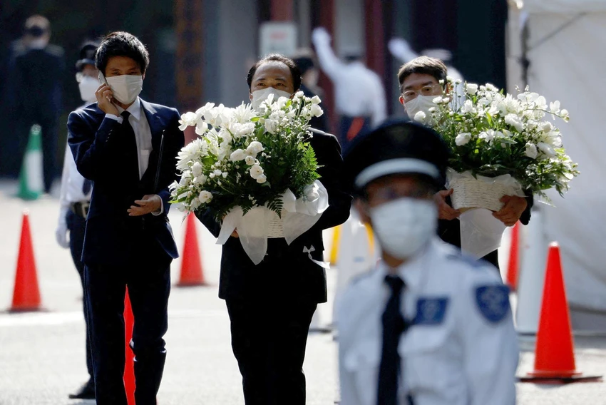 Các quan chức mang hoa đến đền Zojoji ngày 11-7. Ảnh: REUTERS Các quan chức mang hoa đến đền Zojoji ngày 11-7. Ảnh: REUTERS