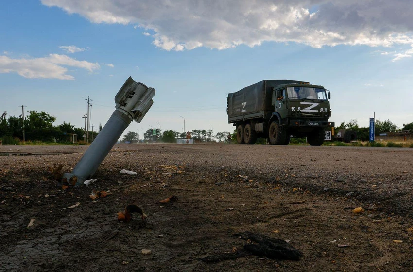 Xe tăng Nga đi qua một quả bom chưa nổ ở làng Chornobaivka, tỉnh Kherson ngày 26-7. Ảnh: REUTERS