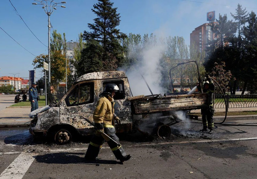 Lính cứu hỏa dập lửa một chiếc xe cháy ở Donetsk do pháo kích hôm 17-9. Ảnh: REUTERS