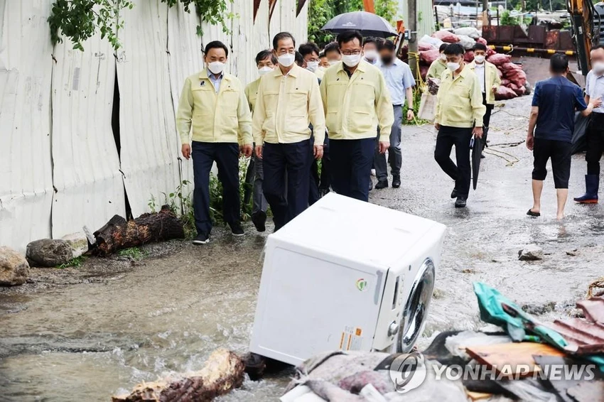 Phái đoàn chính phủ đi kiểm tra thiệt hại tại làng Guryong (Seoul) ngày 9-8. Ảnh: YONHAP Phái đoàn chính phủ đi kiểm tra thiệt hại tại làng Guryong (Seoul) ngày 9-8. Ảnh: YONHAP