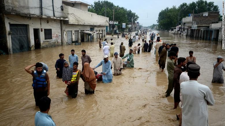 Người di dời lội qua một khu vực ngập nước ở thành phố Peshawar, tỉnh Khyber Pakhtunkhwa (Pakistan) ngày 27-7. Ảnh: CNN Người di dời lội qua một khu vực ngập nước ở thành phố Peshawar, tỉnh Khyber Pakhtunkhwa (Pakistan) ngày 27-7. Ảnh: CNN