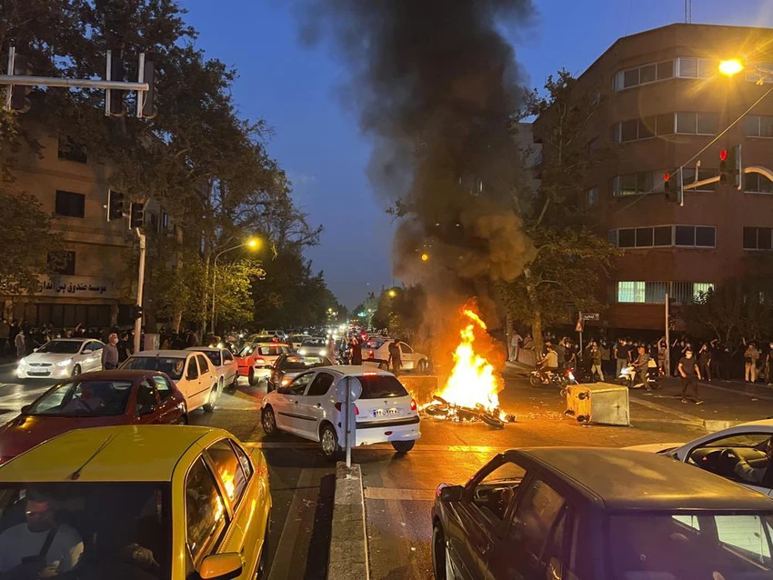 Người biểu tình đốt cháy xe cảnh sát Iran tại thủ đô Tehran (Iran) ngày 19-9. Ảnh: AP