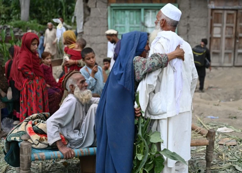 Người dân Afghanistan bên ngoài ngôi nhà bị hư hại ở làng Mazar Dara, huyện Nurgal, tỉnh Kunar, miền đông Afghanistan ngày 1-9. Ảnh: AFP
