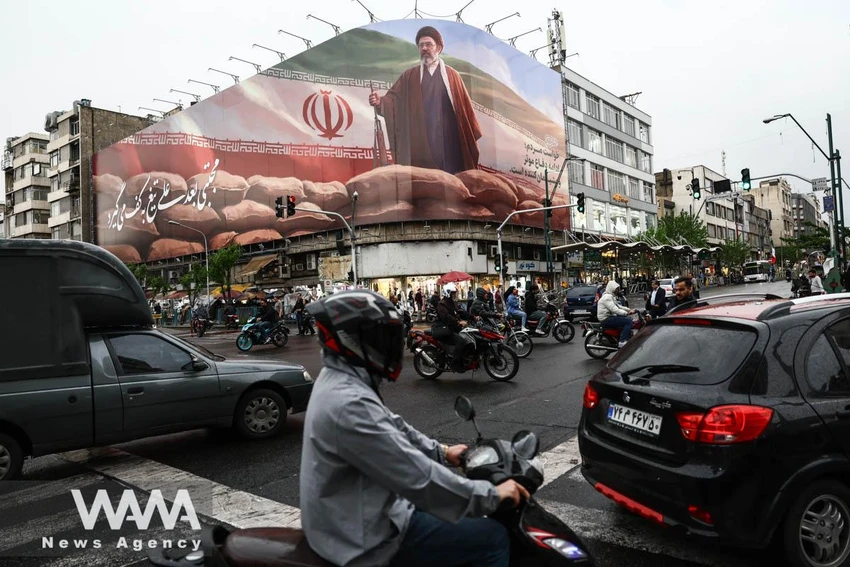 Người đi xe máy chạy qua một bảng quảng cáo có hình ảnh tân Lãnh tụ Tối cao Iran Mojtaba Khamenei tại Tehran ngày 20-4. Ảnh: Majid Asgaripour/WANA