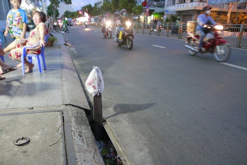 Nhiều người dân sinh sống tại khu vực phải cắm tạm thanh gỗ để cảnh báo cho người đi đường. Ảnh: MT Nhiều người dân sinh sống tại khu vực phải cắm tạm thanh gỗ để cảnh báo cho người đi đường. Ảnh: MT