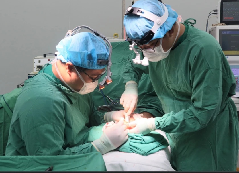 Các bác sĩ đang phẫu thuật tách ngón tay dinh liền cho bé "tay cua". Ảnh: BVCC Các bác sĩ đang phẫu thuật tách ngón tay dinh liền cho bé "tay cua". Ảnh: BVCC