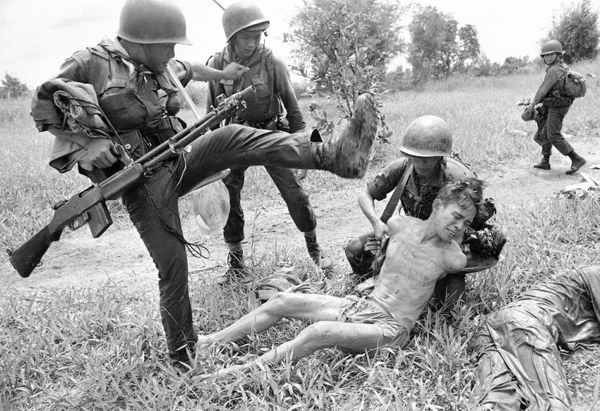 Lực lượng VNCH đánh một người bị tình nghi là quân Giải phóng trong tháng 10/1965. Ông là một trong 15 người bị bắt sau trận càn. Ảnh:AP Chiến tranh Việt Nam qua ảnh phóng viên quốc tế