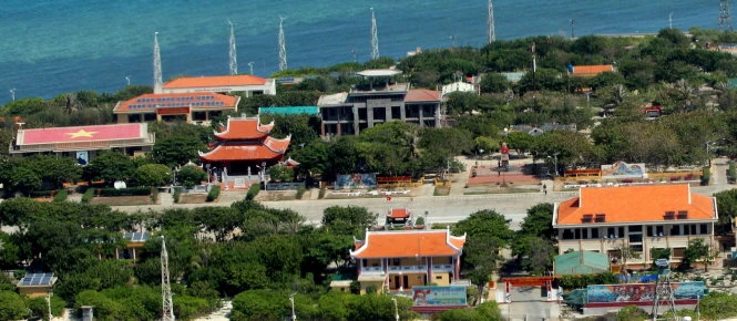 Khu trung tâm thị trấn Trường Sa. Bên trái cổng chào là chùa Trường Sa lớn; bên phải là nhà khách Trường Sa; đối diện chùa là nhà chỉ huy của đảo đang được xây dựng lại. Tiếp theo về phía trái là đài tưởng niệm liệt sĩ; trụ sở UBND thị trấn Trường Sa và hội trường trung tâm với lá cờ tổ quốc trên sân thượng. (Ảnh: VIỄN SỰ)