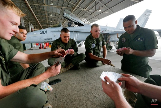 Lính Mỹ đánh bài trong thời gian nghỉ giải lao. Họ đang sửa một chiếc F/A-18, máy bay chuyên trách trên tàu sân bay, để nó có thể hoạt động trở lại. Nghĩa địa máy bay quân sự lớn nhất thế giới