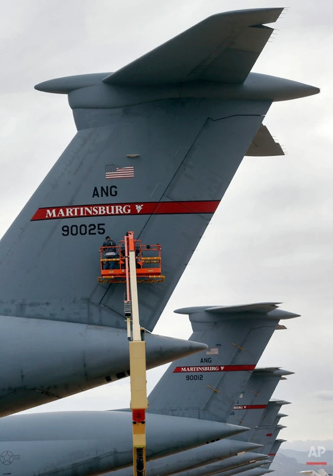 Công nhân lắp khóa cánh lái trên đuôi một máy bay vận tải chiến lược Lockheed C-5 Galaxy. Nghĩa địa máy bay quân sự lớn nhất thế giới