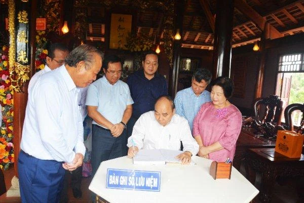 Chủ tịch nước Nguyễn Xuân Phúc ghi vào sổ lưu niệm tại khu lưu niệm. Ảnh: Thành Phát