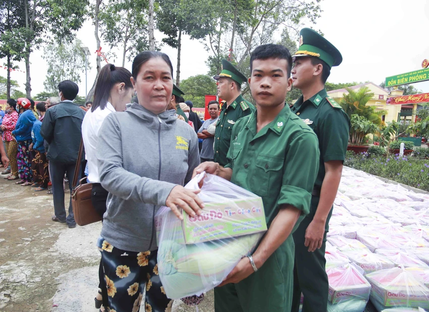 Người dân vui mừng nhận quà từ các chiến sĩ bộ đội biên phòng trao tặng. Ảnh: HUỲNH DU Xuân biên phòng ấm lòng dân biên giới ở Long An