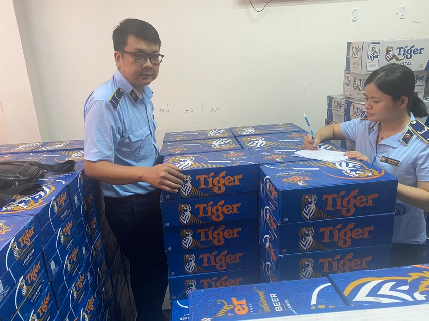 Quản lý thị trường lập biên bản, thu giữ bia ngoại nghi nhập lậu. Ảnh: HỮU CHÍ