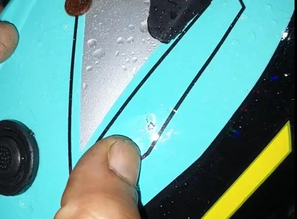 Vết trầy trên nón bảo hiểm của người chồng nghi do đạn bắn trúng. Ảnh cắt từ clip trên Facebook vết trầy trên nón bảo hiểm người chồng nghi do trúng đạn