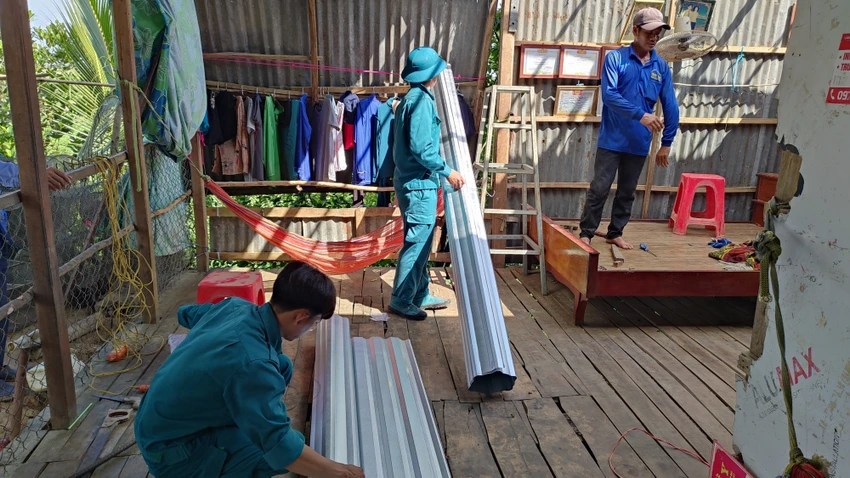 Lực lượng dân quân đến hỗ trợ người dân khắc phục, sửa chữa. Ảnh: DUY PHƯỚC sau cơn mưa giông một phụ nữ bị sét đánh tử vong