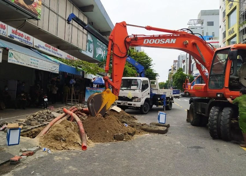 Lực lượng chức năng huy động nhiều máy móc để đào đường cống, đưa thi thể lên. Ảnh: H.H