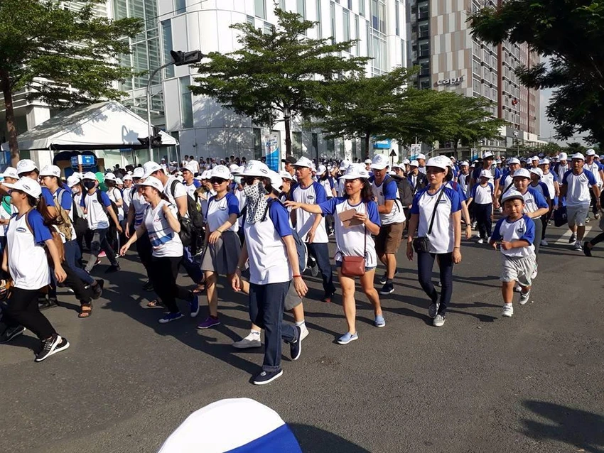 Trẻ con đi bộ cùng người lớn.